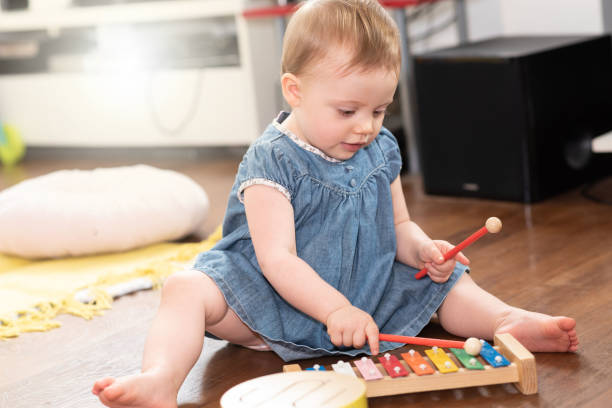 Baby girl playing on a xylophone stock photo