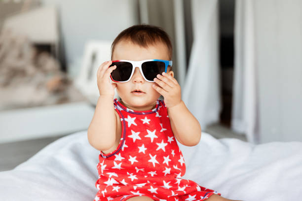 Baby girl wearing sunglasses and red dress on Independence Day on 4th of July stock photo
