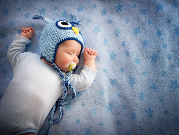 baby in owl hat sleeping stock photo