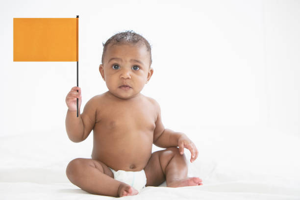 Baby in white background holding a flag stock photo