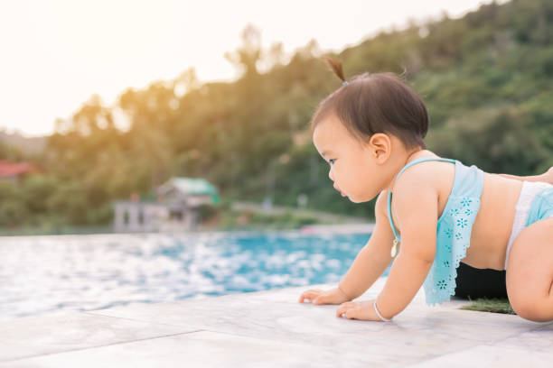 Baby infant tries to crawl down to the pool alone with danger. Baby infant tries to crawl down to the pool alone with danger. close to stock pictures, royalty-free photos & images