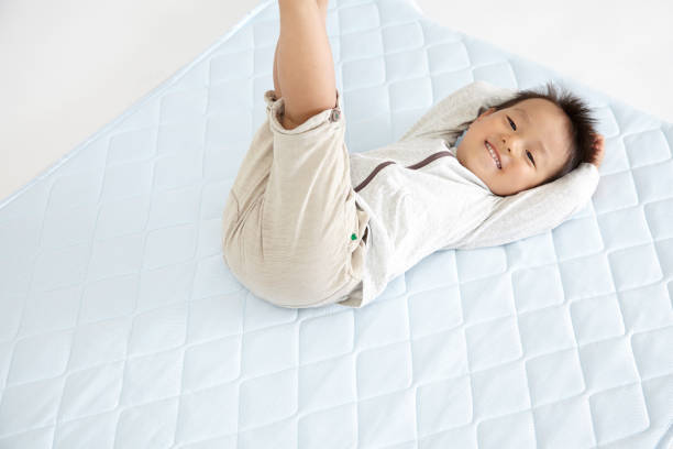 bebé japonés se encuentran en el hombre de colchón - mattresses for children  fotografías e imágenes de stock