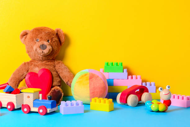 baby kid speelgoed collectie op blauwe en gele achtergrond - speelgoed stockfoto's en -beelden