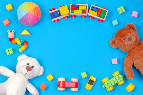 bebek çocuk oyuncakları arka plan. i̇ki oyuncak ayılar, ahşap tren, oyuncak arabalar, mavi arka planda renkli bloklar - teddy ray stok fotoğraflar ve resimler