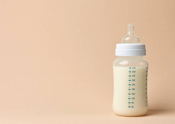 baby milk bottle baby milk bottle on beige background baby formula stock pictures, royalty-free photos & images