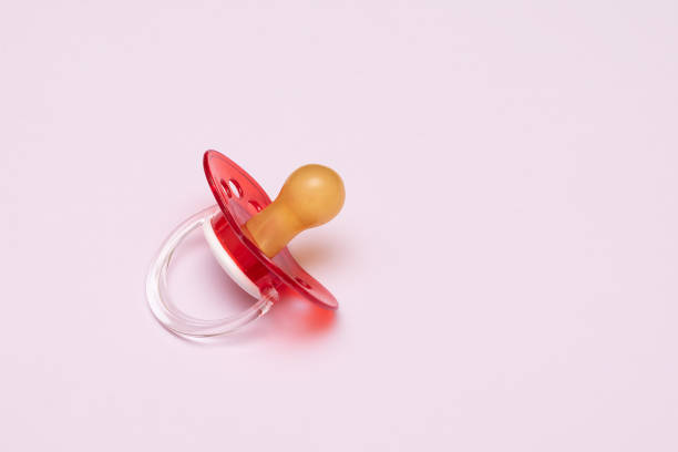 Baby new red pacifier on pink background. stock photo