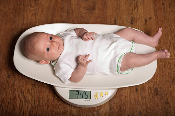 Baby on scales stock photo