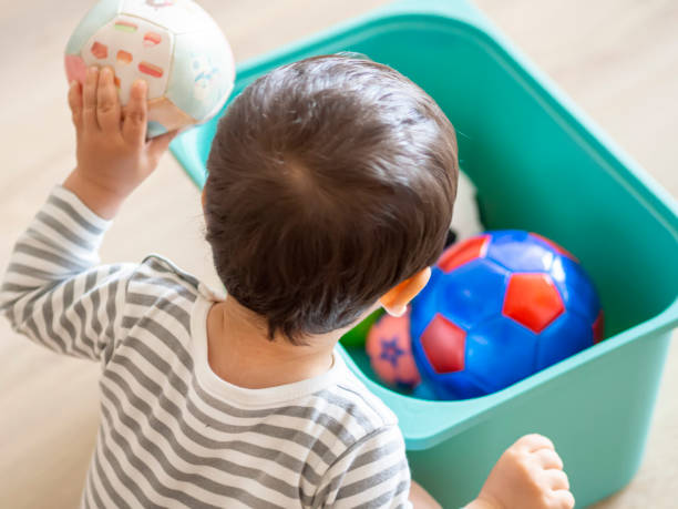 Baby playing with balls toys at home. stock photo