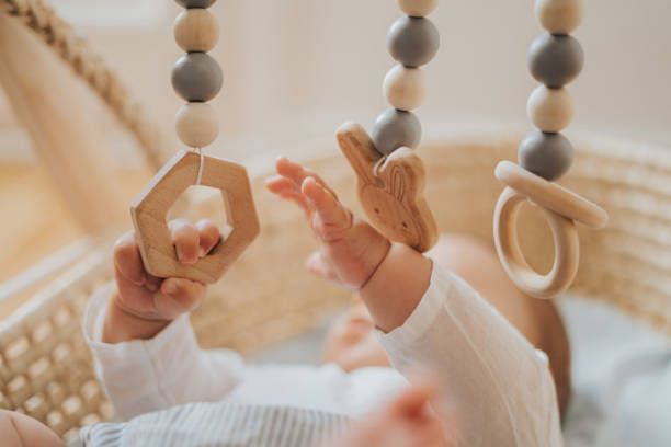 het spelen van de baby met mobiel die van hout wordt gemaakt - cradle to cradle stockfoto's en -beelden