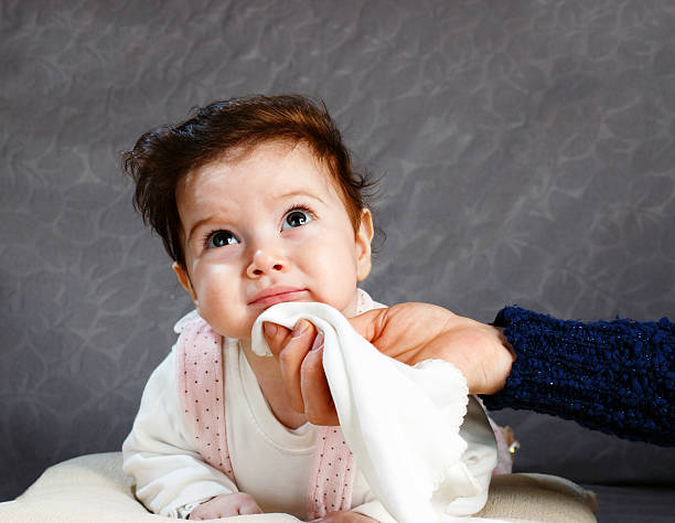 Baby tooth itch and mouth water Mother cleans the baby with baby wipes washcloth stock pictures, royalty-free photos & images