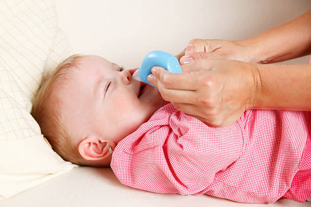 Baby with nasal vacuum stock photo