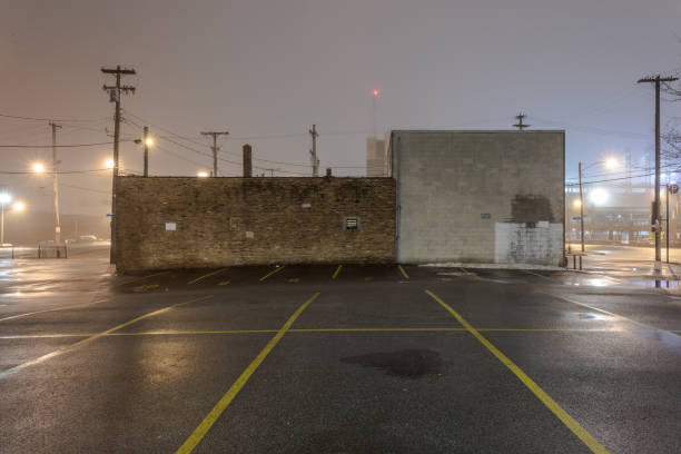 Back of a vintage industrial building in urban area with street lights and fog stock photo