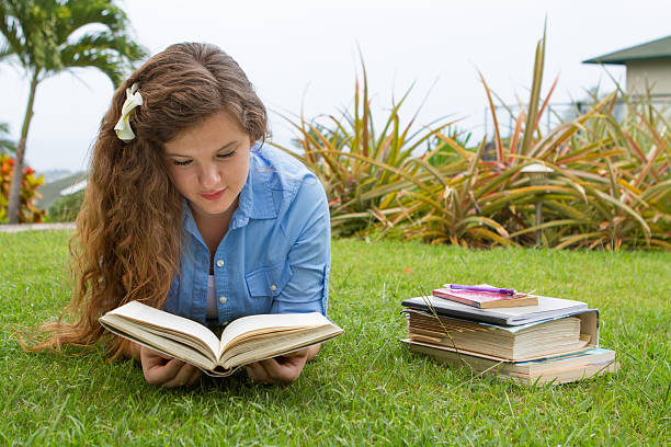 Back to School Pretty teen girl studying her school books outside in a tropical setting. neicebird stock pictures, royalty-free photos & images