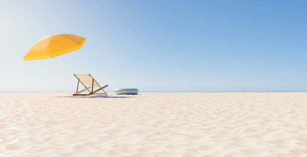 back view of a chair with umbrella on the beach stock photo