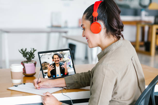 Back view of business latin woman talking to her mexican colleagues in video conference business team using laptop for a online meeting in video call working from home in Latin America stock photo