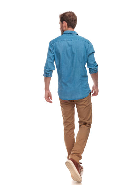 back view of  casual man walking and looking to side back view of a casual young man walking and looking to side on white background rear view stock pictures, royalty-free photos & images