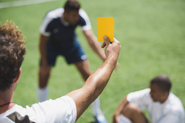 achteraanzicht van de gele kaart tonen aan spelers tijdens spel voetbalscheidsrechter - gele kaart stockfoto's en -beelden