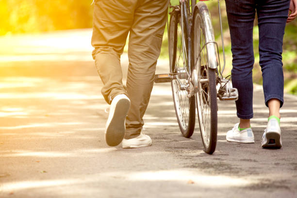 Back view of young couple walking  together with bicycle in the garden Back view of young couple walking  together with bicycle in the garden in vintage color tone asian girls feet stock pictures, royalty-free photos & images