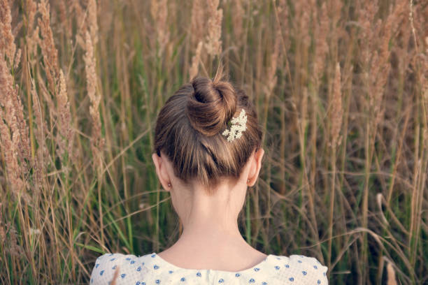 Back view of young woman with hair bun"n stock photo