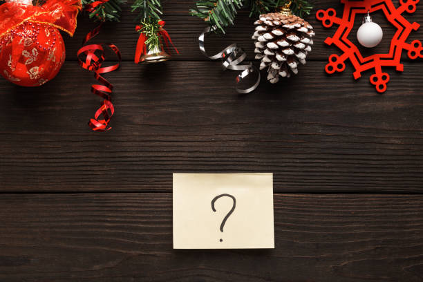 Background for Christmas, wooden backdrop with decorations and question sign, what to do on Christmas eve. stock photo