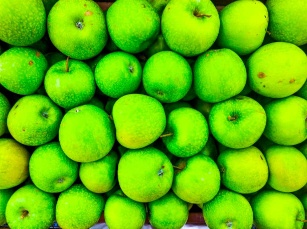 Background of green apples in the market. Ripe fruits on the counter. stock photo