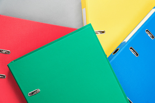 Stationery office multicolored folders randomly stacked on one another, as a background