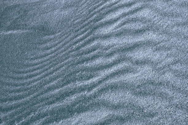 Background, texture, wave pattern of oceanic sand on the beach, blue-gray stock photo