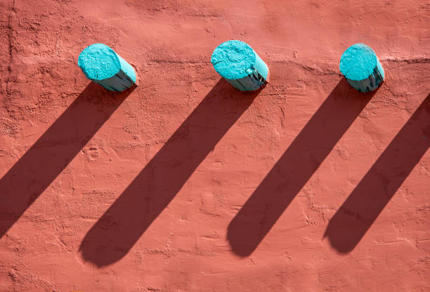 Background - Turquoise corbels and their long shadows on an orange stucco wall on southwestern style building  adobe backgrounds stock pictures, royalty-free photos & images