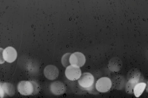 background with window and rain drops and city lights bokeh on the outside stock photo