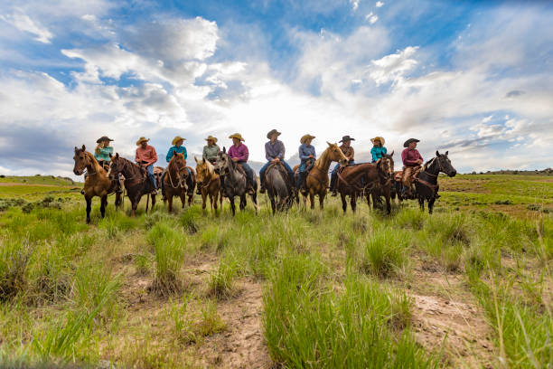 bakgrundsbelyst linje av en grupp cowboys och cowgirls - cowboy horse bildbanksfoton och bilder