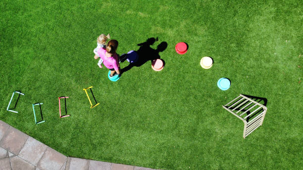 Backyard Obstacle Course - Family fitness at home. Young boy exercising outside, birds eye view from drone. stock photo