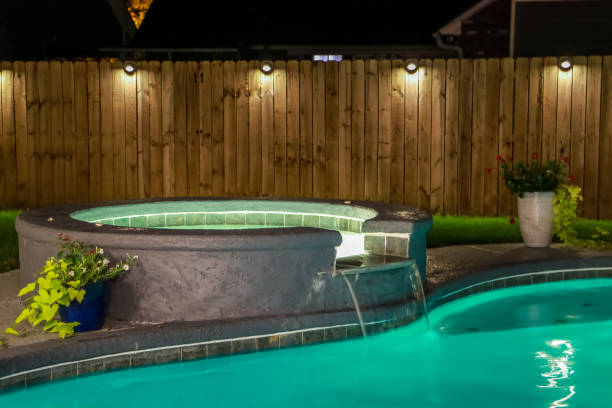 A backyard swimming pool and Hot Tub hot tob at night stock photo