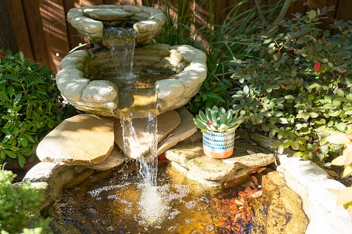 Antique fountain in garden. Water flowing from stone fountain, beauty design.