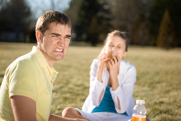 Bad Date Young man cringing as his date stuffs her face. bad date stock pictures, royalty-free photos & images