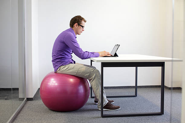 bad sitting posture at tablet on stability ball stock photo