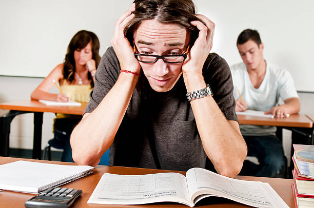 Bad Student A young man freaks out because he doesn't understand his Math problem. toughest exams stock pictures, royalty-free photos & images