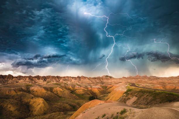 Badlands underneath a dark, powerful lightning storm stock photo