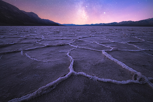 Beautiful, inspiring landscape and halite texture of the Badwater Basin salt flats under a milky way galaxy night sky at Death Valley National Park, USA.
