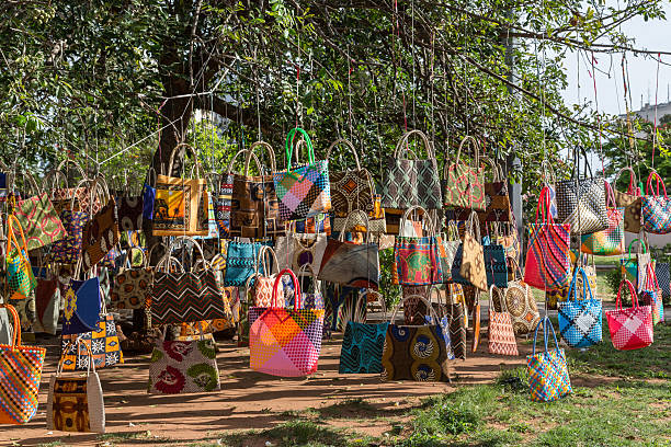 Bag Market A street market in Maputo, Mozambique where hand crafted bags are displayed by hanging them on a tree maputo city stock pictures, royalty-free photos & images