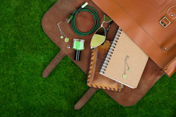bag, note pad, purse, nail polish essentials on the grass stock photo