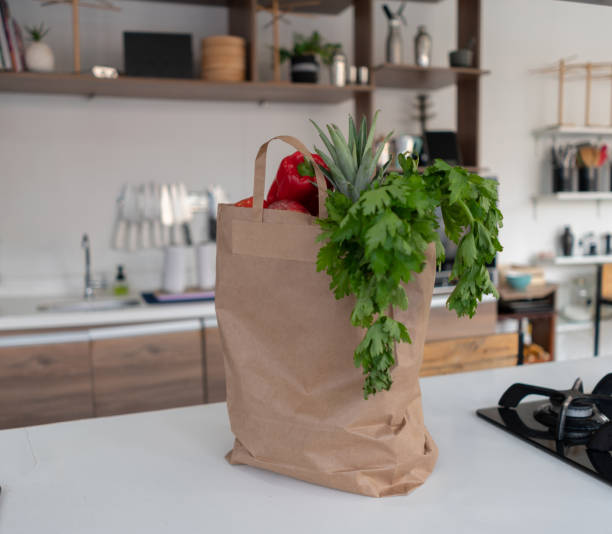 bag of fresh groceries on top of the  kitchen counter - thuisbezorgd food stockfoto's en -beelden