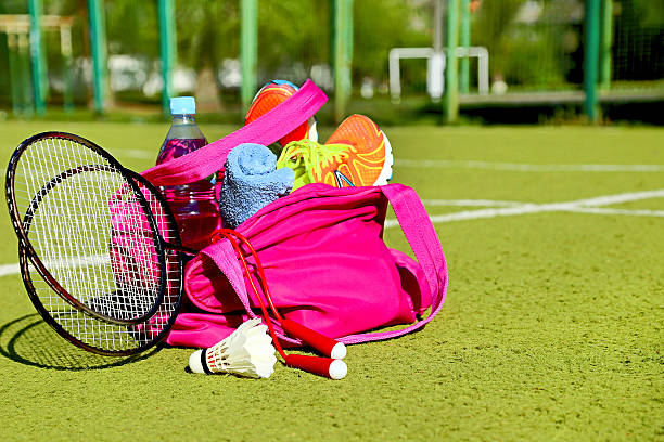 Bag with sports equipment on the sports courts background. Badminton...