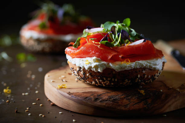 Bagel with Smoked Salmon and Cream Cheese Smoked Salmon and Cream Cheese Bagel on a cutting board smoked salmon photos stock pictures, royalty-free photos & images