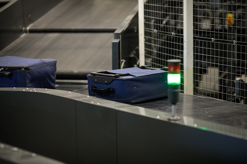 Baggage on a conveyor belt inside a luggage sorting system at an airport.