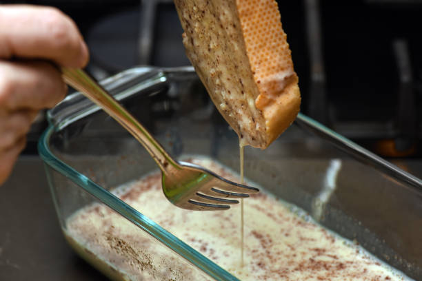 baguette slice soaking in french toast mixture - rabanada imagens e fotografias de stock