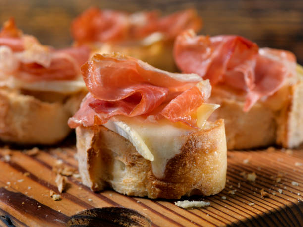 Baked Brie and Crispy Prosciutto Canapes Baked Brie and Crispy Prosciutto Canapes crostini photos stock pictures, royalty-free photos & images