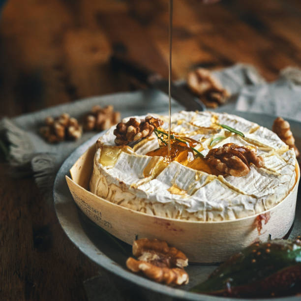 baked camembert cheese served with honey and fresh figs - kaasplank stockfoto's en -beelden