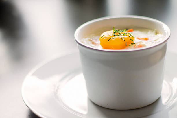 Baked egg Baked egg with chive and pepper in ramekin. casserole stock pictures, royalty-free photos & images