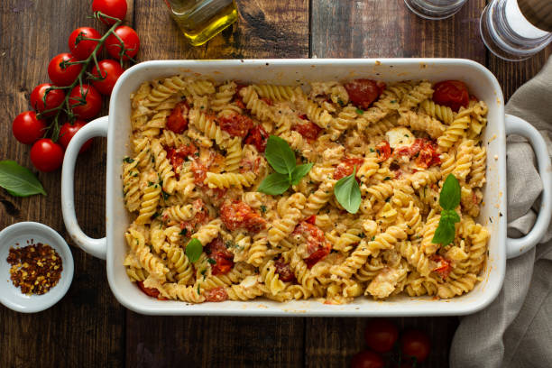 Baked feta pasta with cherry tomatoes and herbs stock photo