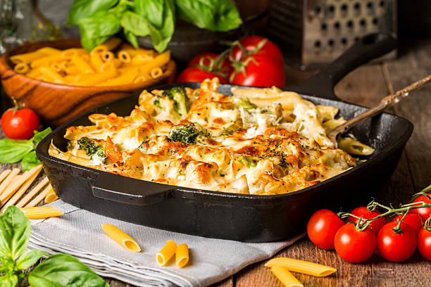 Baked pasta with broccoli, cauliflower, cheese and bechamel sauc Baked pasta with broccoli, cauliflower, cheese and bechamel sauce in a frying pan on wooden bachfround casserole stock pictures, royalty-free photos & images